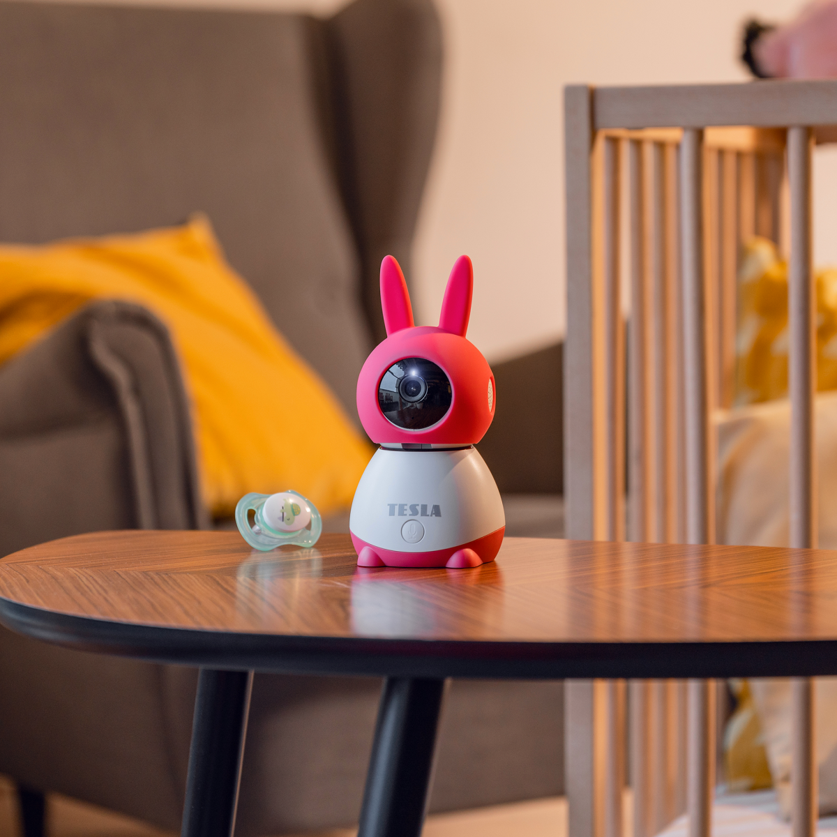 Chůvička TESLA Smart Camera 360 Baby je umístěná na dřevěném stole vedle dětské postýlky